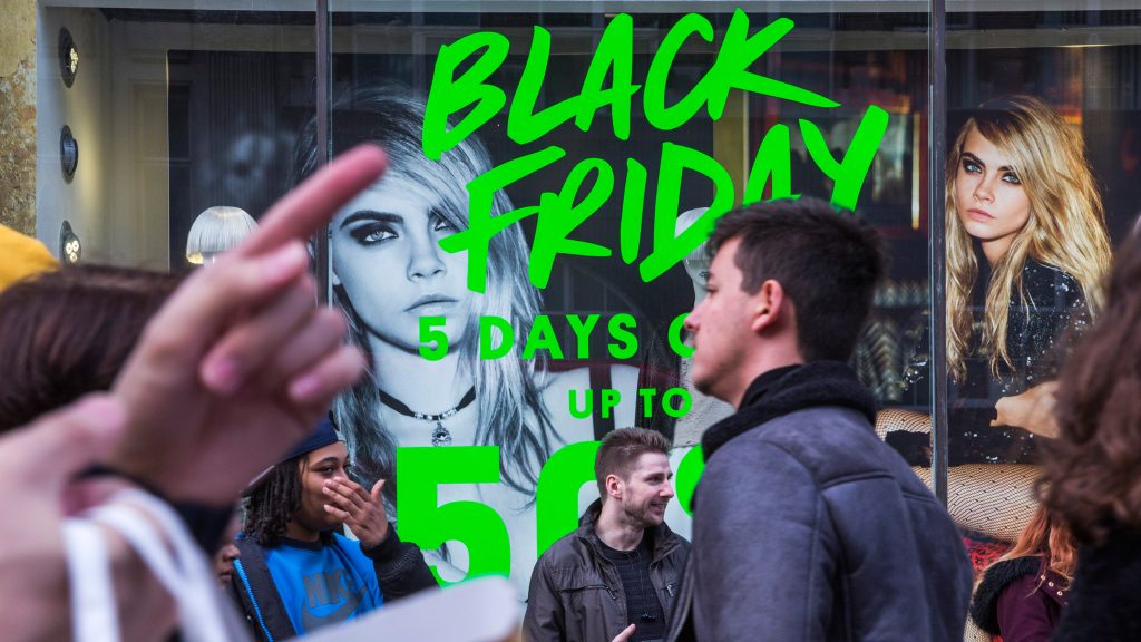 LONDON, ENGLAND - NOVEMBER 28: People walk past a shopfront on Oxford Street advertising 'Black Friday' discounts on November 28, 2014 in London, England. Originating in the USA as a sales day that following the Thanksgiving holiday, 'Black Friday' is becoming an increasingly popular shopping day in the UK. (Photo by Rob Stothard/Getty Images)