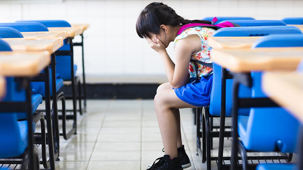 sad girl sitting and  thinking in the classroom