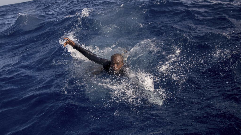 A migrant tries to board a boat of the German NGO Sea-Watch in the Mediterranean Sea on November 6, 2017.
During a shipwreck, five people died, including a newborn child. According to the German NGO Sea-Watch, which has saved 58 migrants, the violent behavior of the Libyan coast guard caused the death of five persons.

 / AFP PHOTO / Alessio Paduano