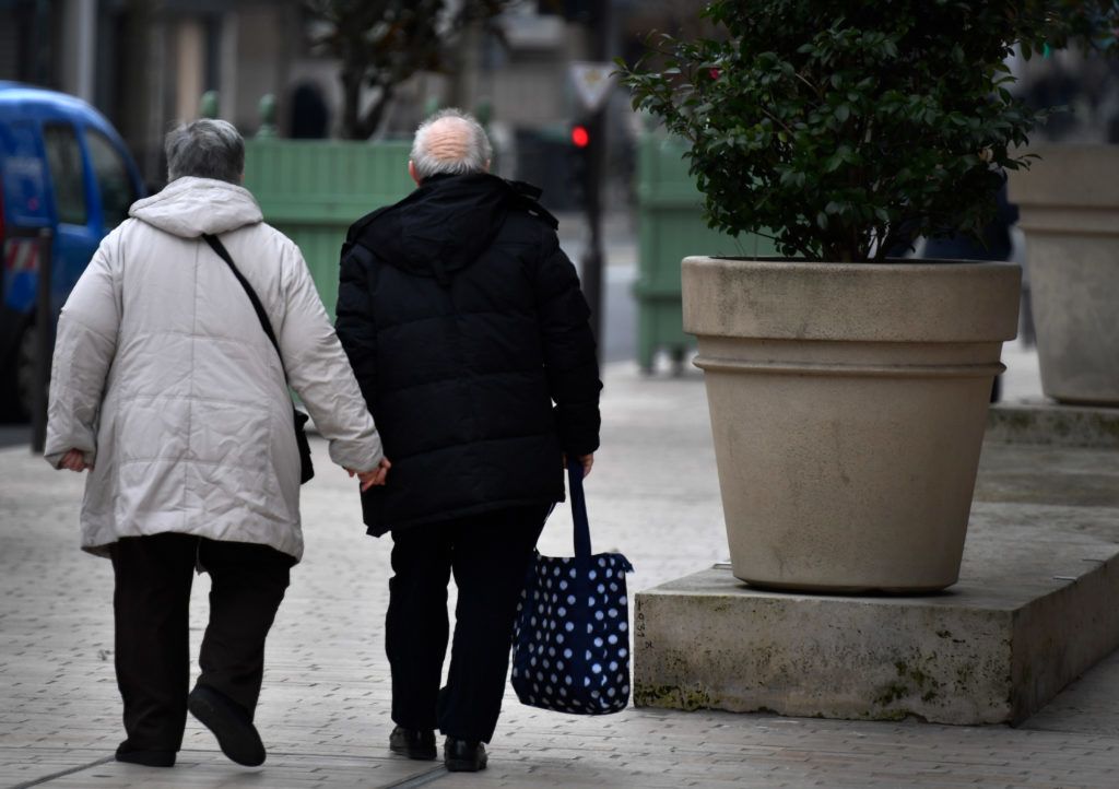 An elderly couple walk in Vincennes near Paris on February 19, 2018.
 / AFP PHOTO / GERARD JULIEN