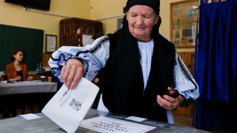 A woman dressed in a traditional outfit votes during the European elections and a referendum at a polling station in Gura Raului village on May 26, 2019. - Bad pupils of the EU in the fight against corruption, Romanians must say if they want to put an end to this phenomenon in a referendum called by centre-right president Klaus Iohannis. (Photo by Ovidiu MATIU / AFP)
