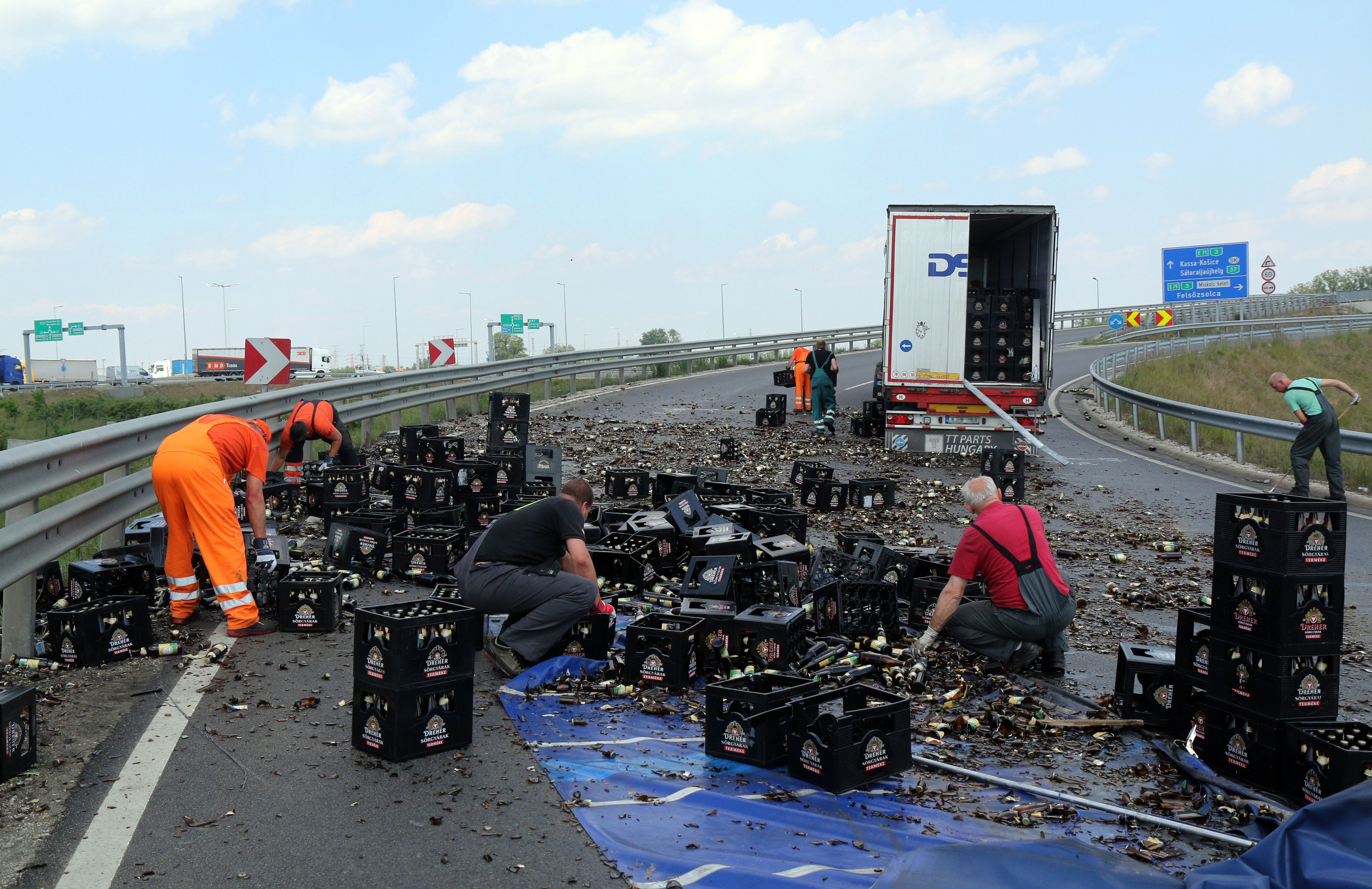 Egy teherautóról az úttestre esett és összetört sörösüvegeket takarítják el az M30-as autópálya lehajtóján Miskolc határában 2020. május 18-án. A kanyarban a teherautó rakományának egy része az úttestre borult. MTI/Vajda János