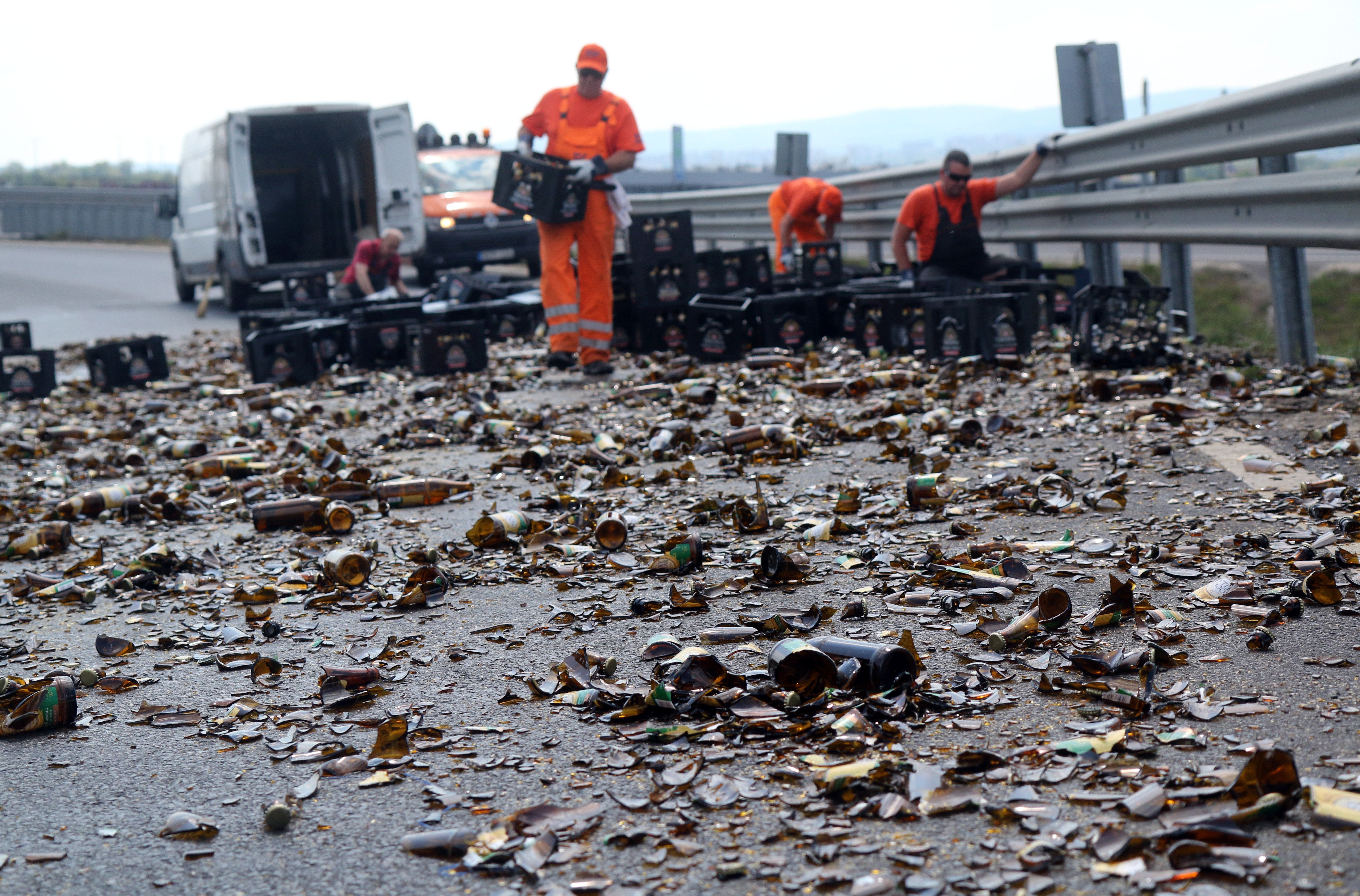 Egy teherautóról az úttestre esett és összetört sörösüvegeket takarítják el az M30-as autópálya lehajtóján Miskolc határában 2020. május 18-án. A kanyarban a teherautó rakományának egy része az úttestre borult. MTI/Vajda János