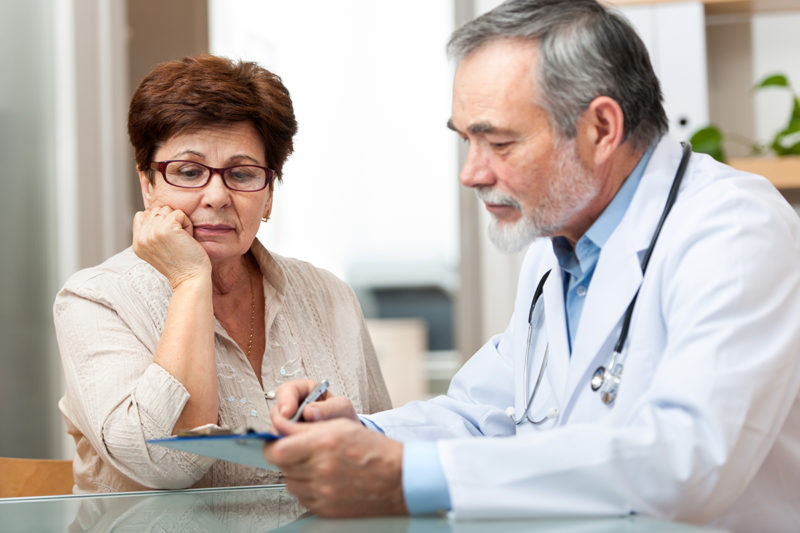 Doctor discussing treatment with senior female patient