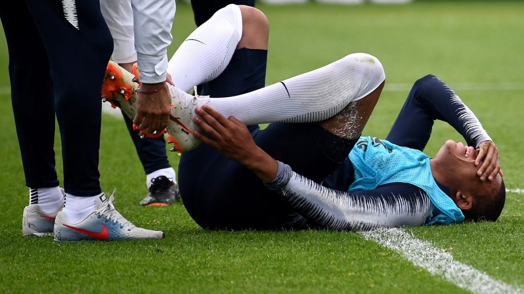 France's forward Kylian Mbappe (C) reacts after getting injured during a training session at the Glebovets stadium in Istra, on June 12, 2018, ahead of the Russia 2018 World Cup football tournament. / AFP PHOTO / FRANCK FIFE
